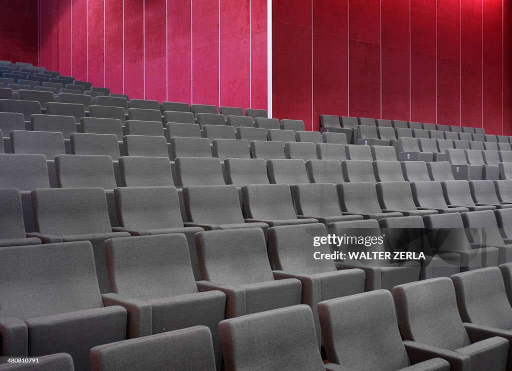 Grey chairs in empty auditorium