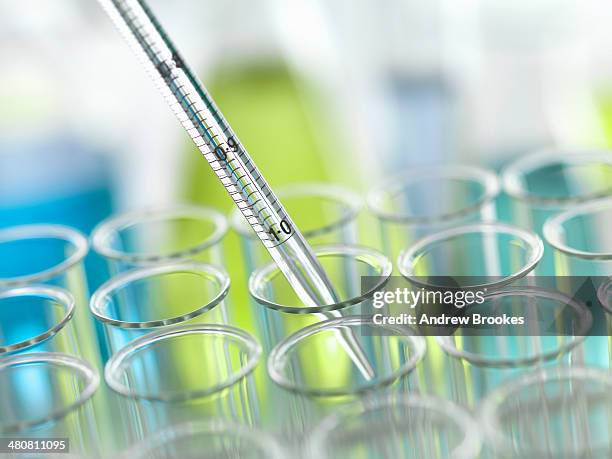 a graduated pipette being inserted into test tube - dna tube stock pictures, royalty-free photos & images