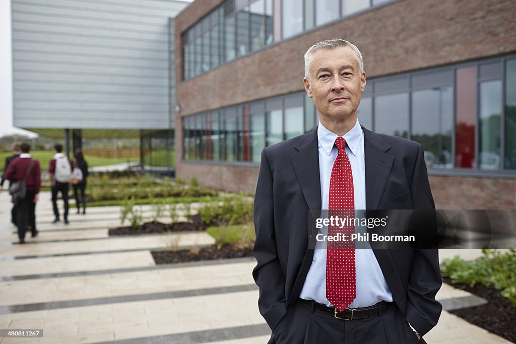 Portrait of mature male teacher outside school