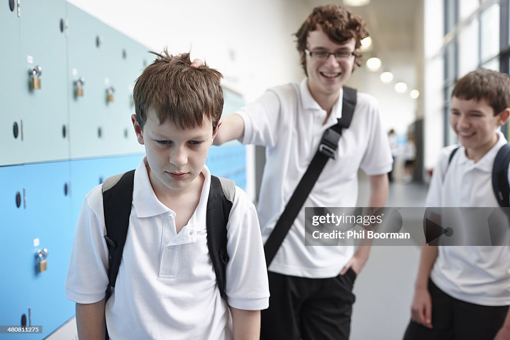 Schoolboy being bullied in school corridor
