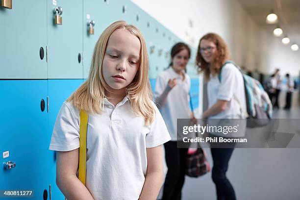 schoolgirl being bullied in school corridor - bully school stock pictures, royalty-free photos & images