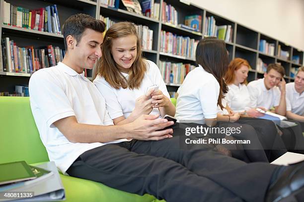 row of teenagers hanging out in library - mobile phone reading low angle stock pictures, royalty-free photos & images