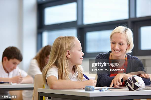 teacher working with schoolgirl in classroom - 12 12 12 2013 film stock-fotos und bilder