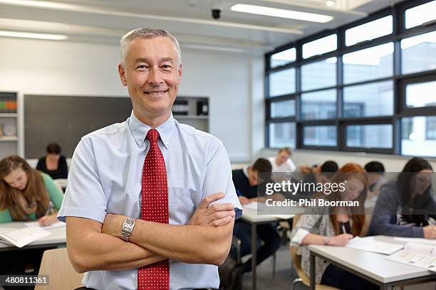 portrait of mature male teacher in classroom - male teacher in a classroom stock-fotos und bilder