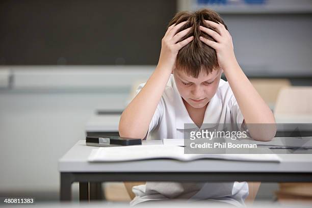 schoolboy struggling in educational exam - schulkind nur jungen stock-fotos und bilder