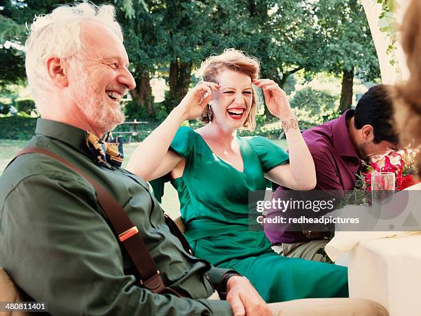 newly married couple with parents laughing at wedding reception - suspenders stock pictures, royalty-free photos & images