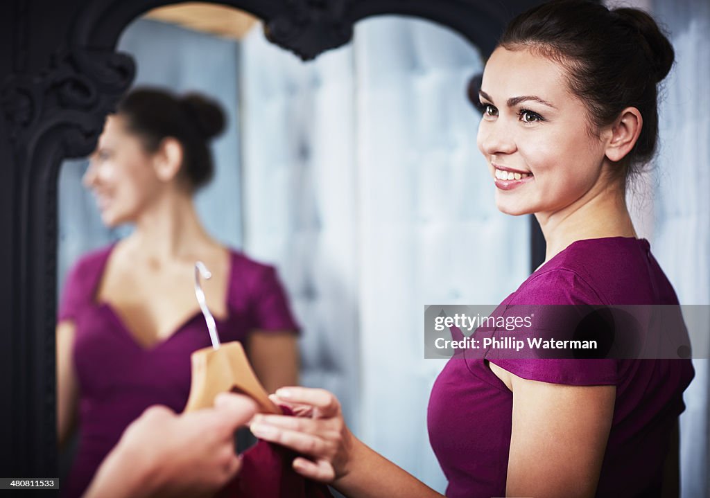 Young woman trying on dress