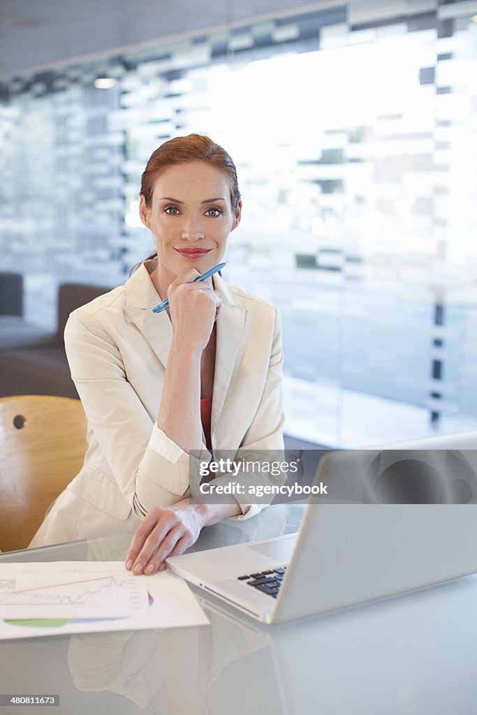Businesswoman sitting at desk, writing activity