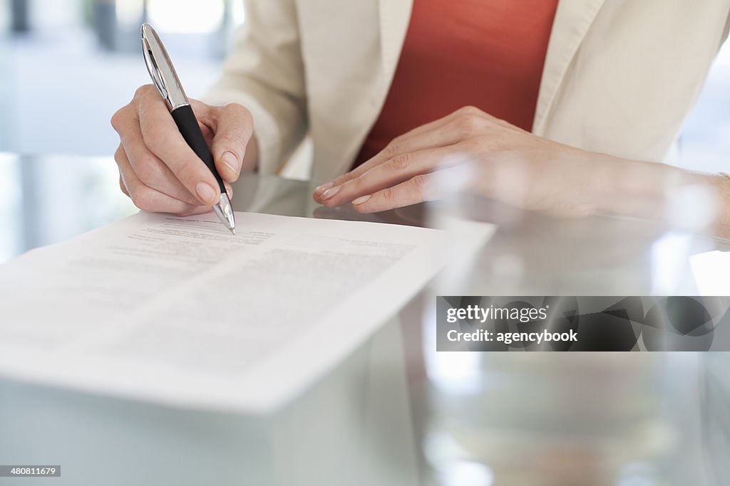 Cropped image of businesswoman signing paperwork