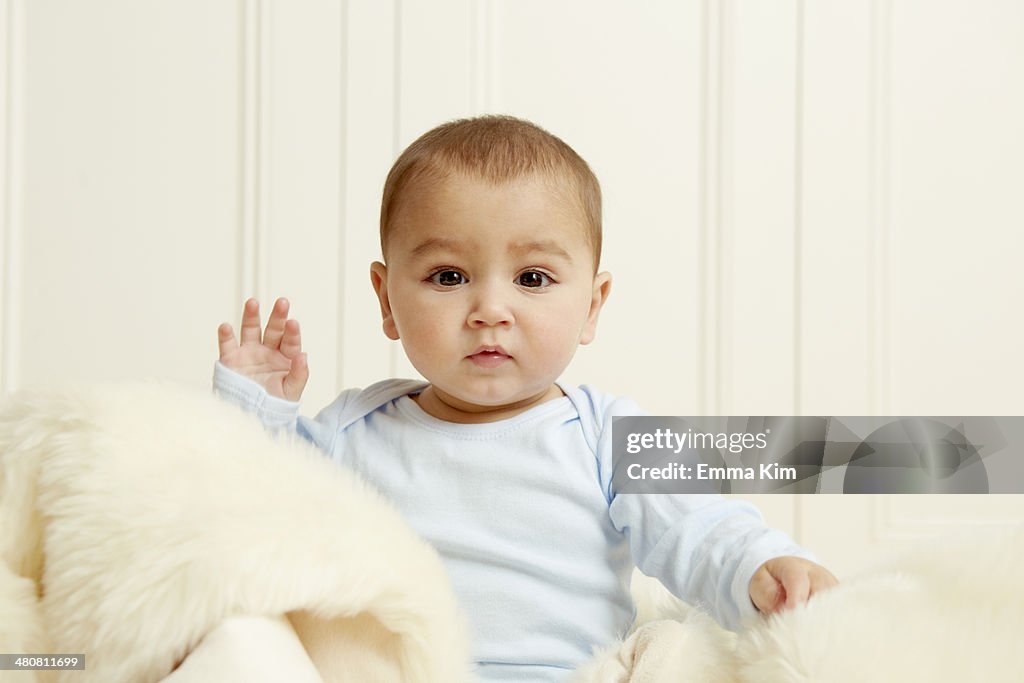 Baby sitting on sheepskin rug