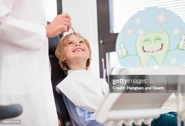 boy in dentists chair having check up - dentista foto e immagini stock