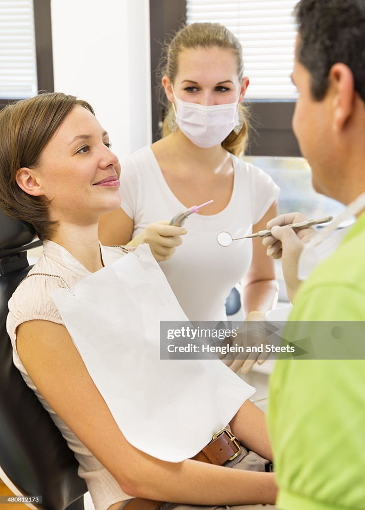 Woman having check up with dentist and dental nurse