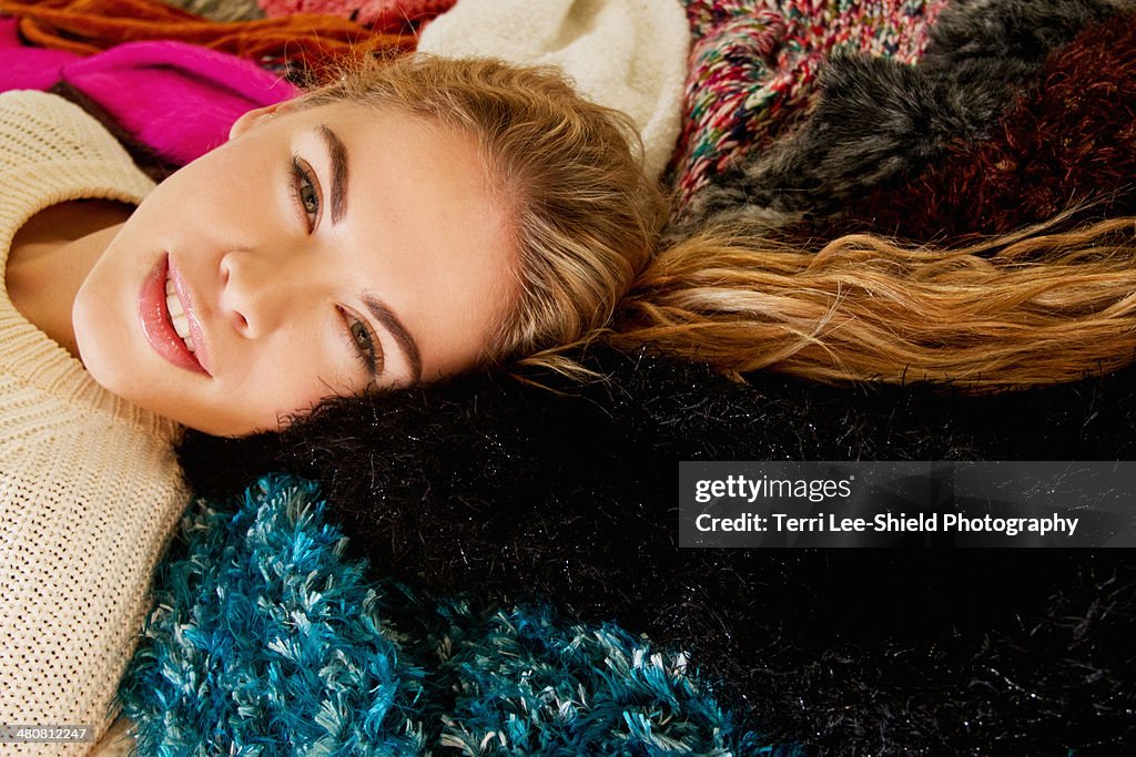 Portrait of young woman lying on furry blanket