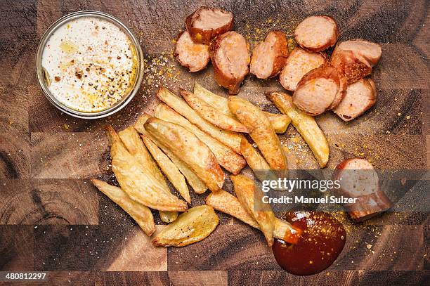 still life of potato fries, ketchup and currywurst - currywurst stock pictures, royalty-free photos & images