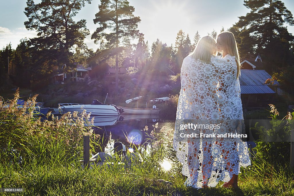 Two young adult female friends wrapped in blanket, Gavle, Sweden