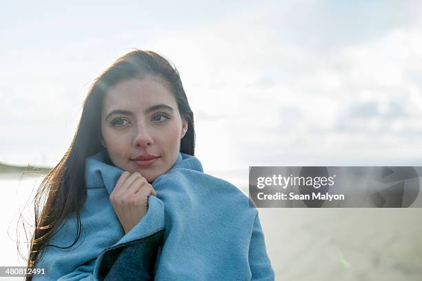 young woman wrapped in blanket - sean malyon stock-fotos und bilder