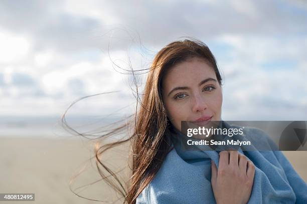 young woman wrapped in blanket - sean malyon stock pictures, royalty-free photos & images