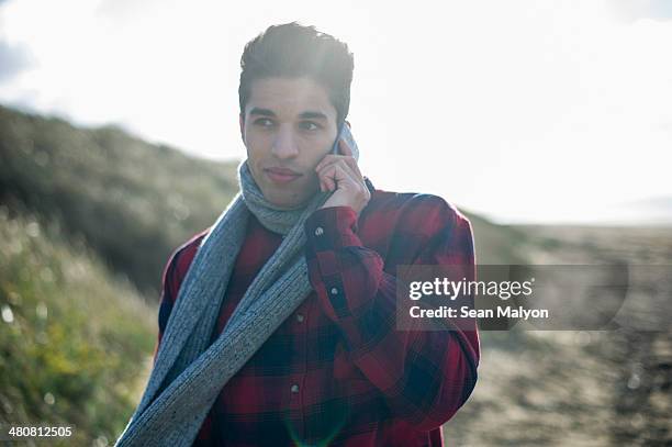 young man using smartphone - sean malyon stock-fotos und bilder