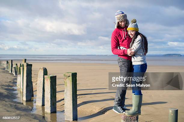 young couple standing on groynes, brean sands, somerset, england - sean malyon stock-fotos und bilder