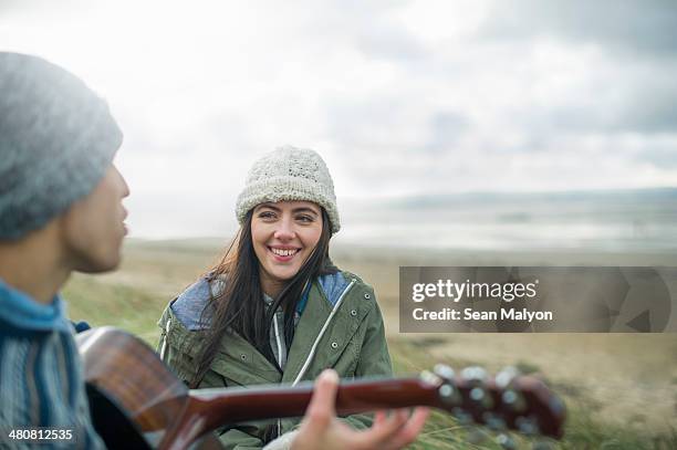 young man playing guitar, brean sands, somerset, england - een serenaden brengen stockfoto's en -beelden