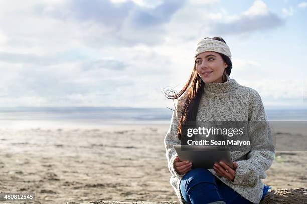 young woman using digital tablet, brean sands, somerset, england - sean malyon stockfoto's en -beelden