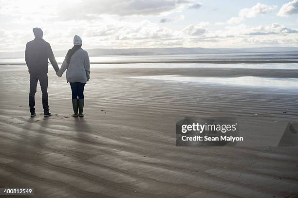 young couple holding hands, brean sands, somerset, england - sean malyon stock-fotos und bilder