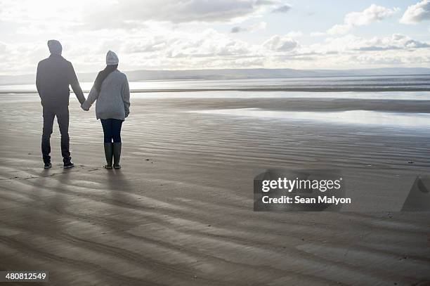 young couple holding hands, brean sands, somerset, england - sean malyon stock pictures, royalty-free photos & images