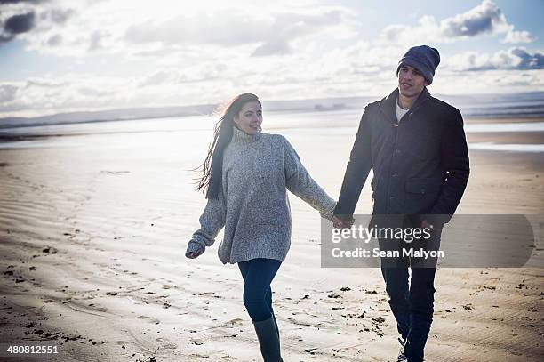 young couple holding hands, brean sands, somerset, england - sean malyon stock pictures, royalty-free photos & images