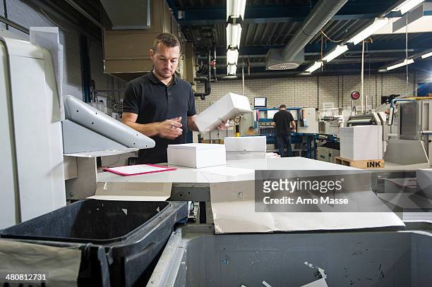 worker preparing paper for machine in print workshop - article de presse photos et images de collection