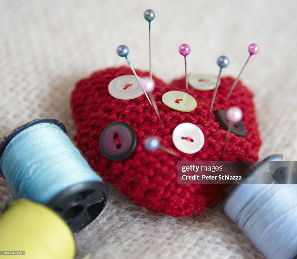 Heart-shaped pin cushion. buttons and thread