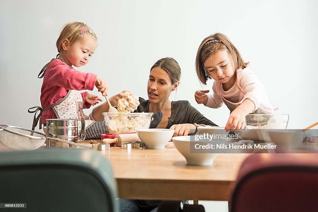 Mother and children baking, mixing batter