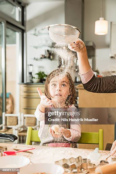 mother and daughter sieving flour in kitchen - sieve stock pictures, royalty-free photos & images