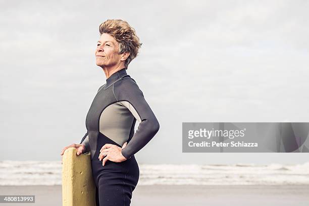 portrait of mature female bodyboarder, devon, uk - three quarter length stock pictures, royalty-free photos & images