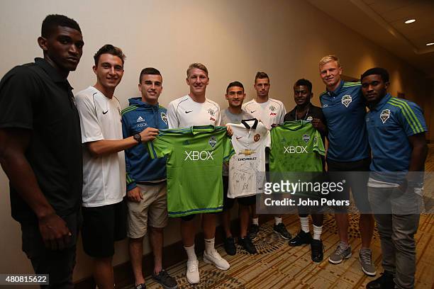 Matteo Darmian, Bastian Schweinsteiger and Morgan Schneiderlin of Manchester United pose with Seattle Sounders players ahead of a press conference to...