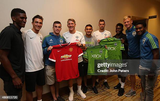 Matteo Darmian, Bastian Schweinsteiger and Morgan Schneiderlin of Manchester United pose with Seattle Sounders players ahead of a press conference to...