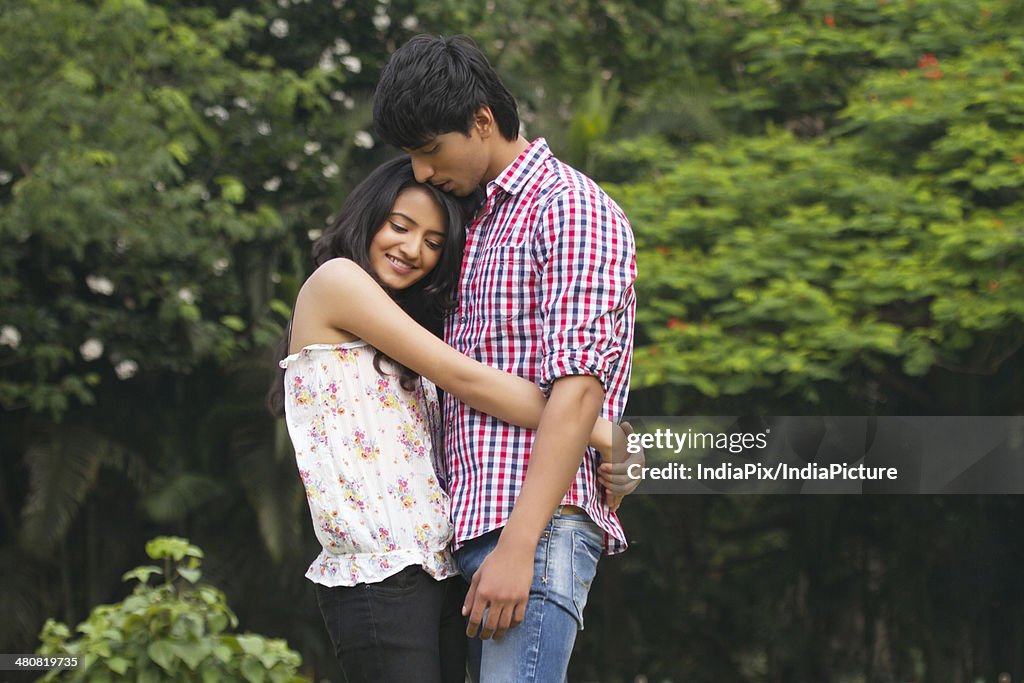 Side view of loving woman embracing man in park