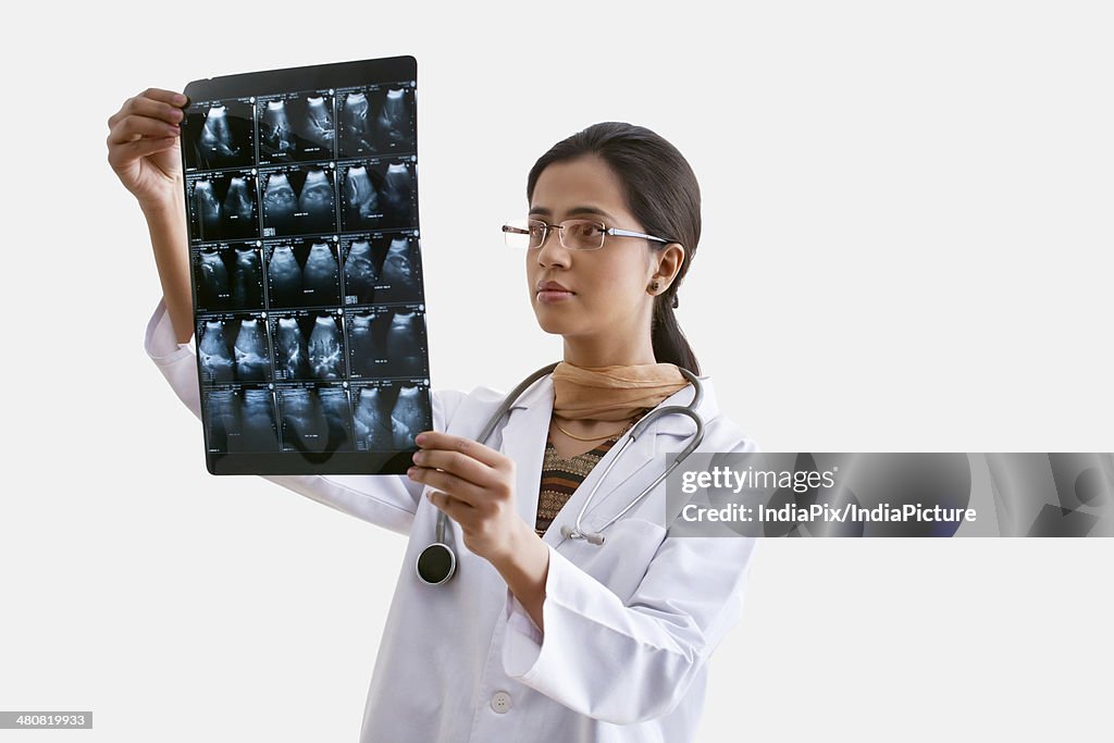 Female doctor analyzing X-ray report isolated over white background