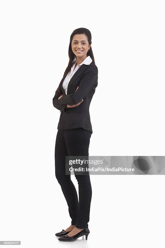 Full length portrait of businesswoman standing arms crossed over white background