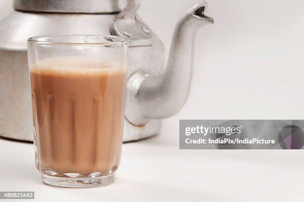 glass of chai with an old fashioned kettle isolated over white background - chai tea stock pictures, royalty-free photos & images