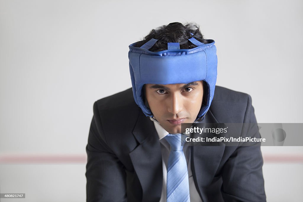 Portrait of businessman with protective headgear in boxing ring