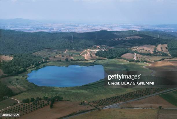 Aerial view of the lake Lago dell'Accesa and the surrounding Metalliferous Hills with Follonica in the background Follonica - Province of Grosseto,...