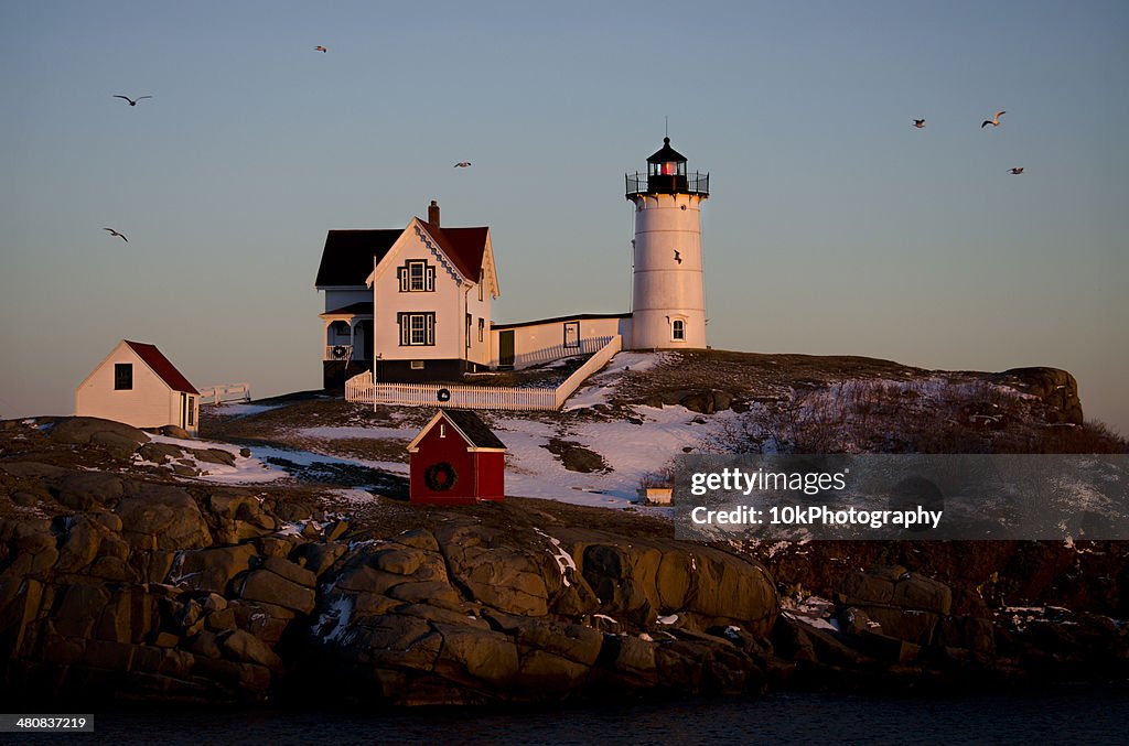 USA, Maine, York County, Cape Neddick Lighthouse in winter sunset