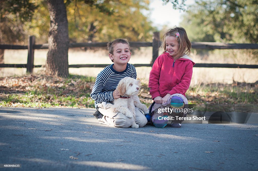 Children and Dog Sitting Together Outdoors