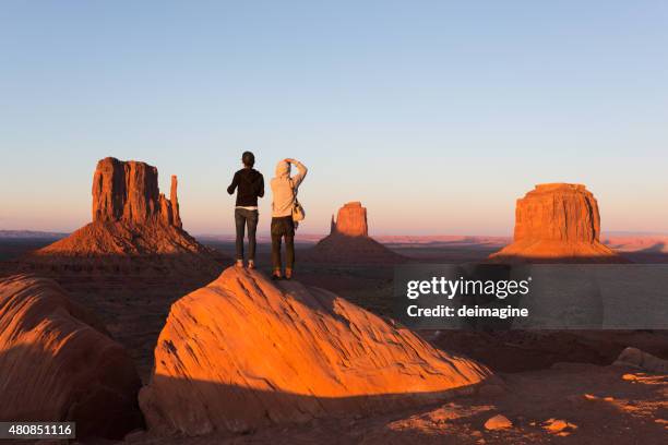 joven pareja disfrutando de monument valley atardecer - monument valley fotografías e imágenes de stock