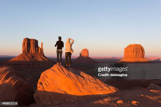 young couple enjoying monument valley sunset - monument valley stock pictures, royalty-free photos & images