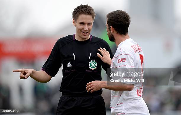 Referee Tobias Reichen discusses with Andreas Guentner of Regensburg during the Third League match between Jahn Regensburg and Preussen Muenster at...