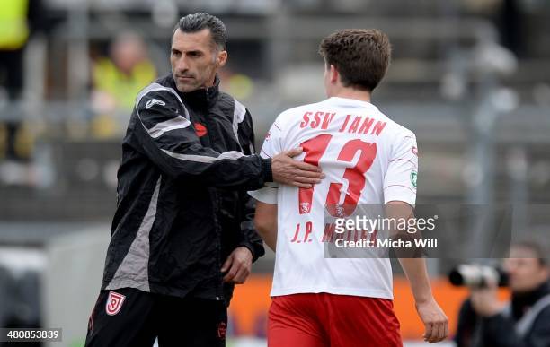 Head coach Thomas Stratos of Regensburg shakes hands with Jim-Patrick Mueller of Regensburg during his substitution during the Third League match...
