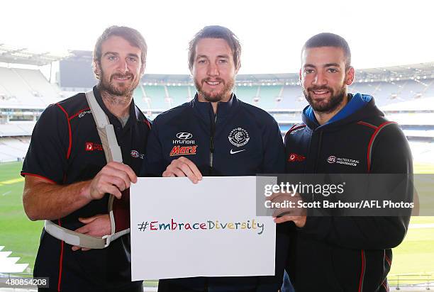 Jobe Watson of the Bombers, Dale Thomas of the Blues and Jimmy Toumpas of the Demons hold an 'embrace diversity' sign during the AFL Multicultural...