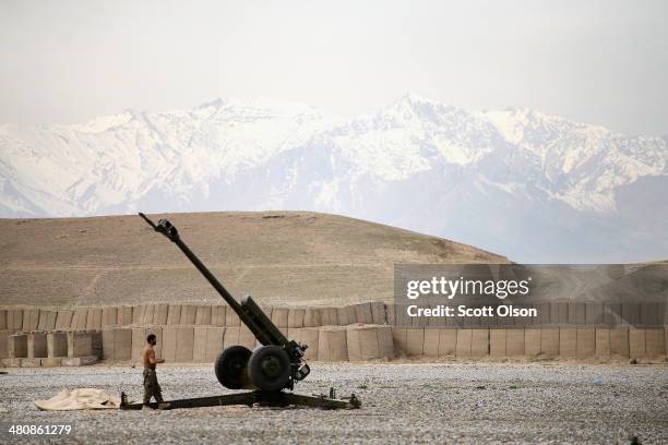 An Afghan National Army soldier performs maintenance on a Russian-made artillery gun at Forward Operating Base Maiwand, an ANA base that adjoins the...