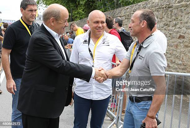 French Minister of Defence Jean-Yves Le Drian greets former champion Luc Leblanc of France while manager of Team Bretagne Seche Environnement...